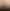 Portraitphoto eines Mannes mit Glatze und Brille vor beigem Hintergrund. Er trägt ein schwarzes Hemd mit leicht geöffnetem Kragen.
